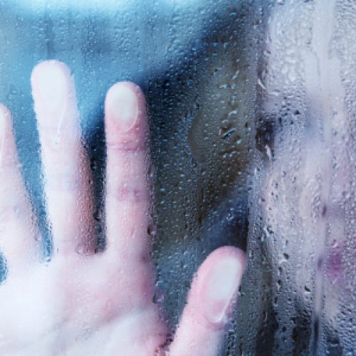 hand of young  woman  melancholy and sad  at the window in the rain